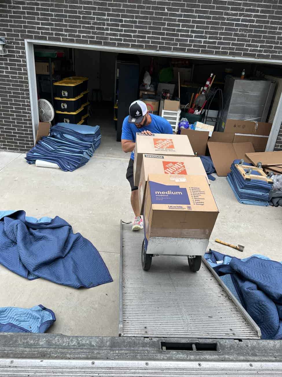 Professional mover from Texas Delta Moving loading boxes onto a truck using a dolly ramp during a residential move in Princeton, Texas.