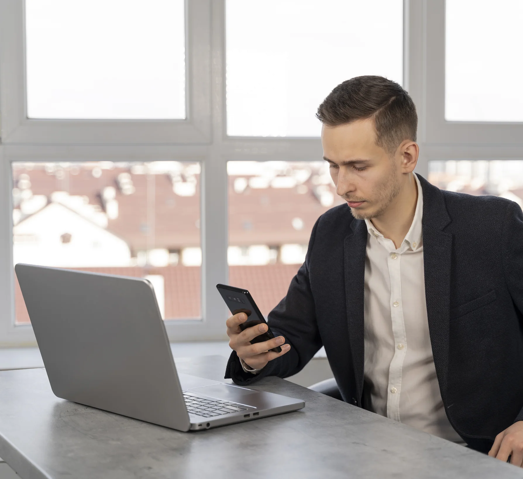 A man is looking at mowing best on his phone.