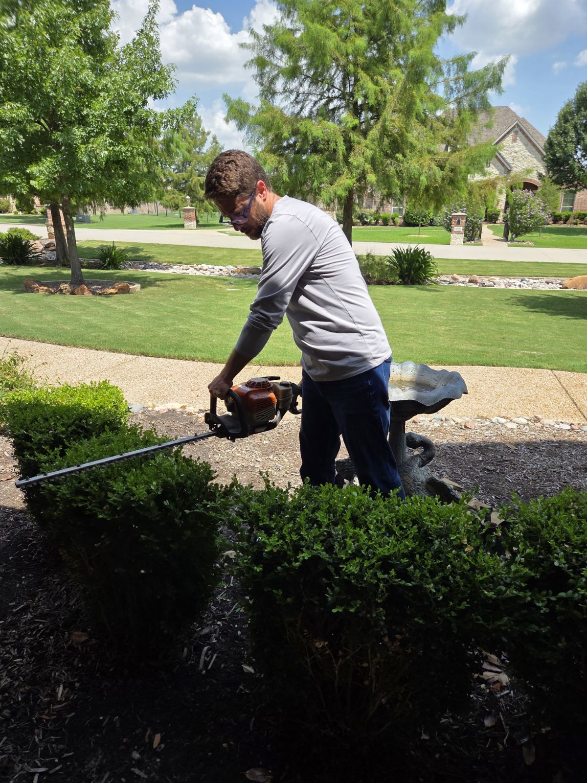 A crew member completing landscape cleanup at a North Texas home