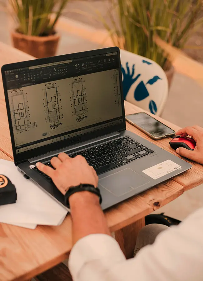 architect reviewing technical drawings on a laptop