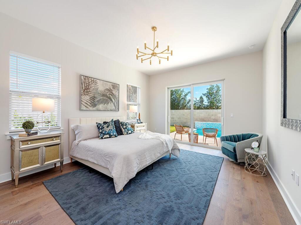 Spacious bedroom with a large bed, blue rug, and sliding doors leading to a pool outside.