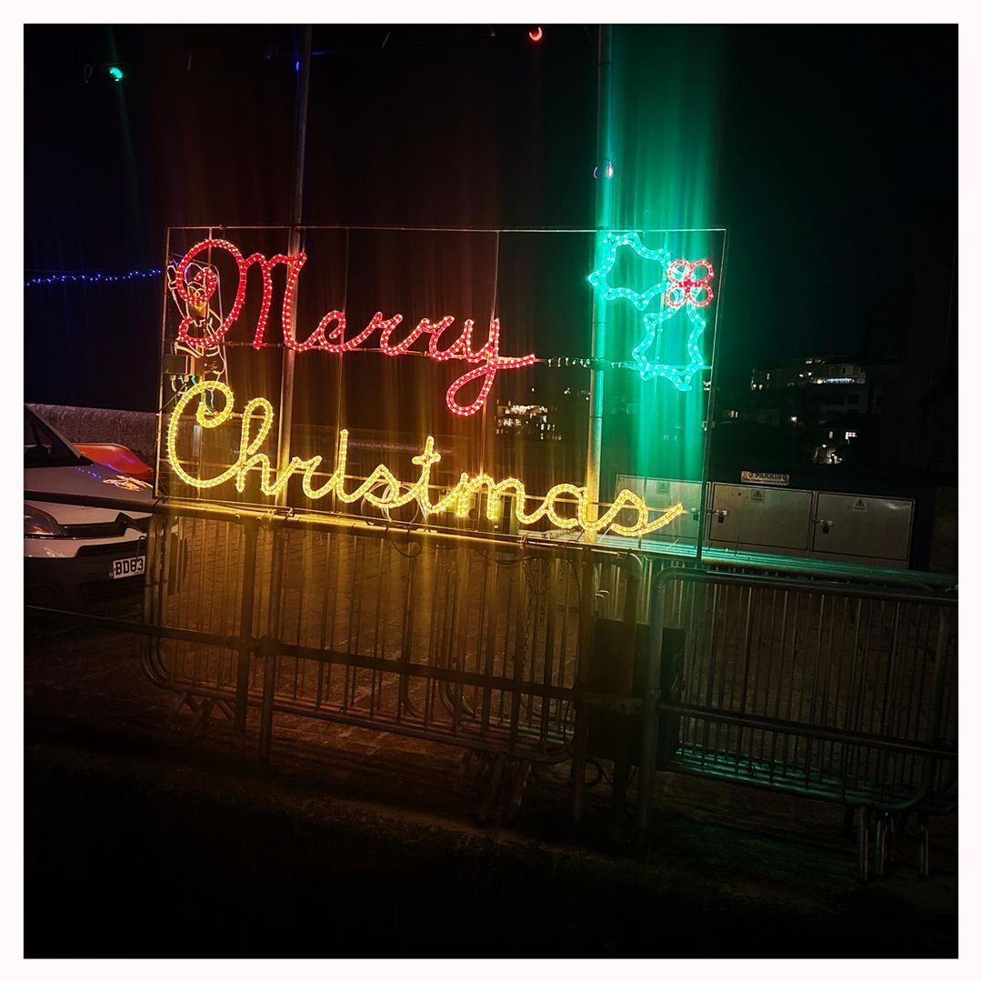 Merry Christmas illuminated sign on the St Ives harbourside at night