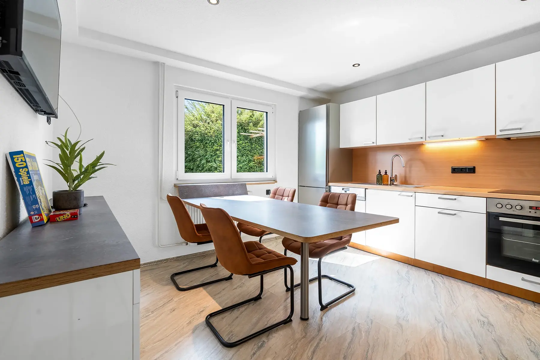 Schlafzimmer mit Doppelbett, gelber Tagesdecke, weißen Handtüchern und stilvollen Wandbildern – gemütlich und modern eingerichtet