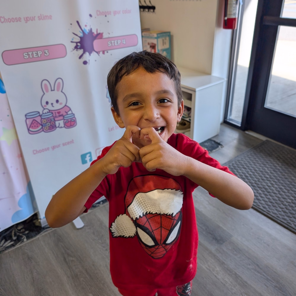 Boy standing in front of Moo Zoo Slime Shop's portable slime bar in Grand Rapids