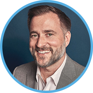 mark poor's headshot. middle aged man with a beard smiling and friendly.
