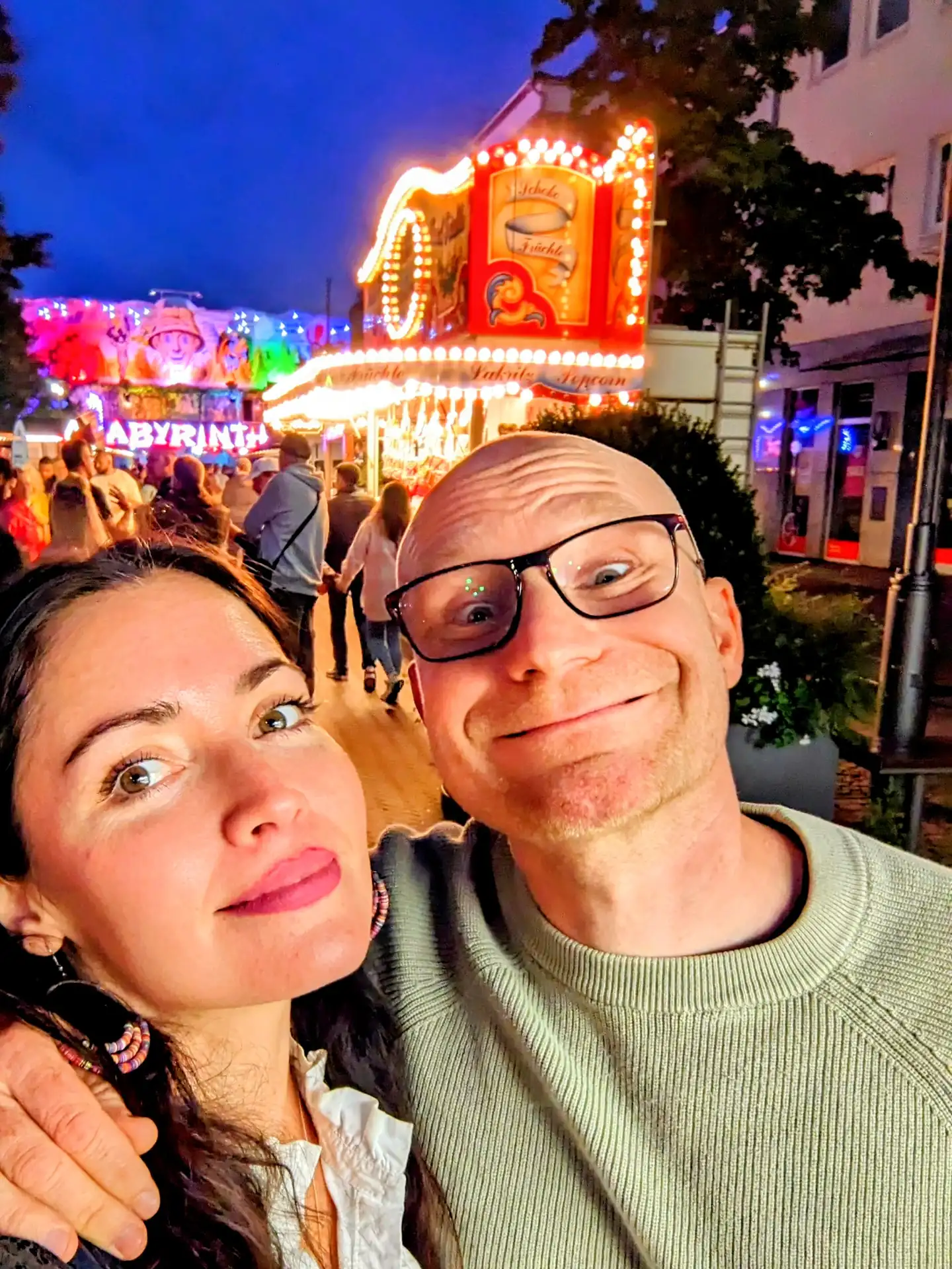 Magdalena und Martin abends vor der beleuchteten Süßigkeiten-Bude auf dem Stadtfest Uelzen