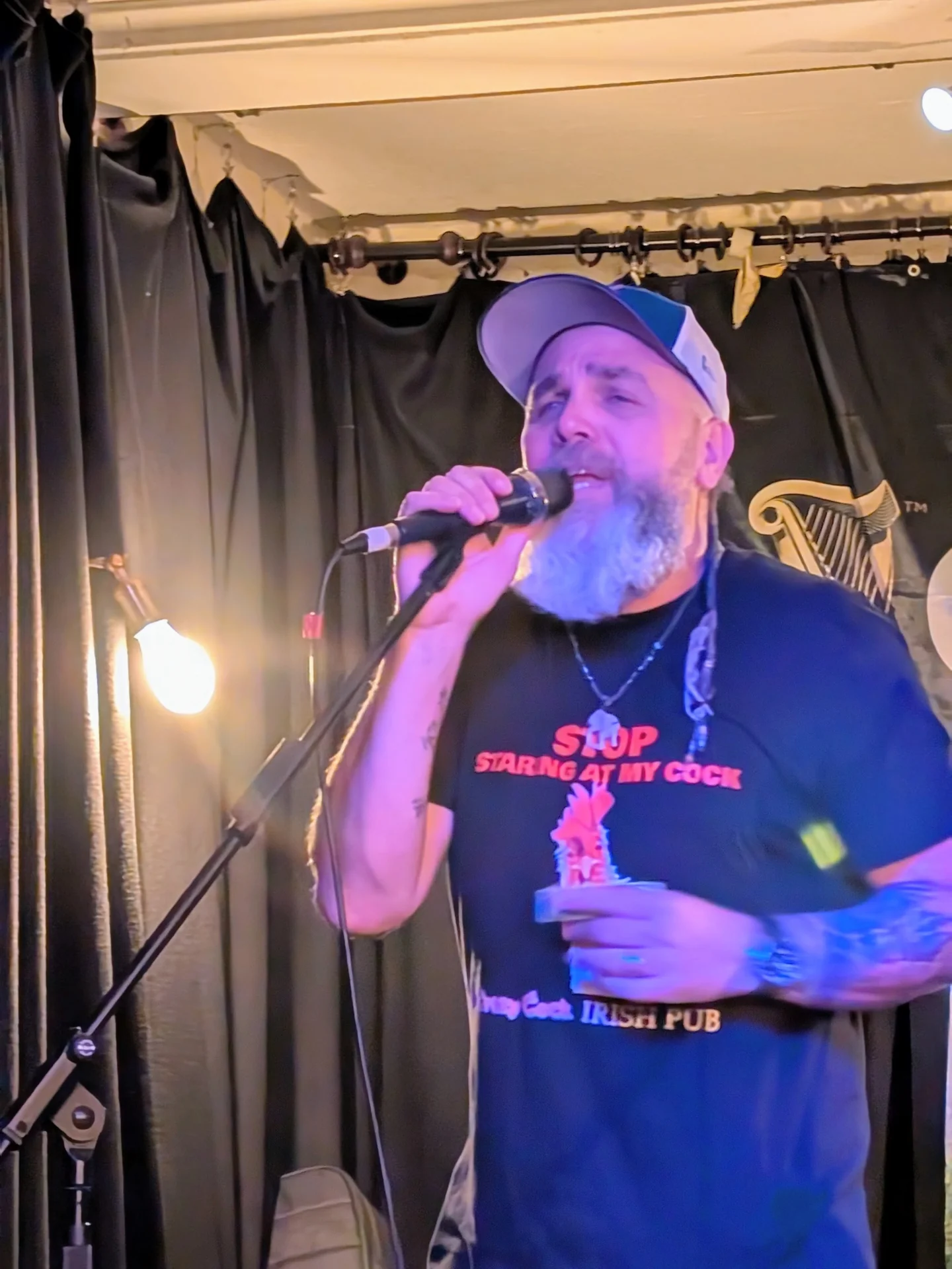 Clint Ivie singt mit Mikrofon auf der Bühne seines Irish Pubs in Uelzen