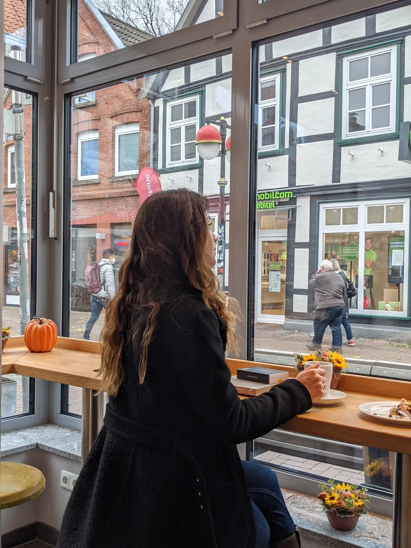 Magdalena am Fensterplatz in der Café-Ecke der Bäckerei Warnecke in Uelzen mit Blick auf die Straße