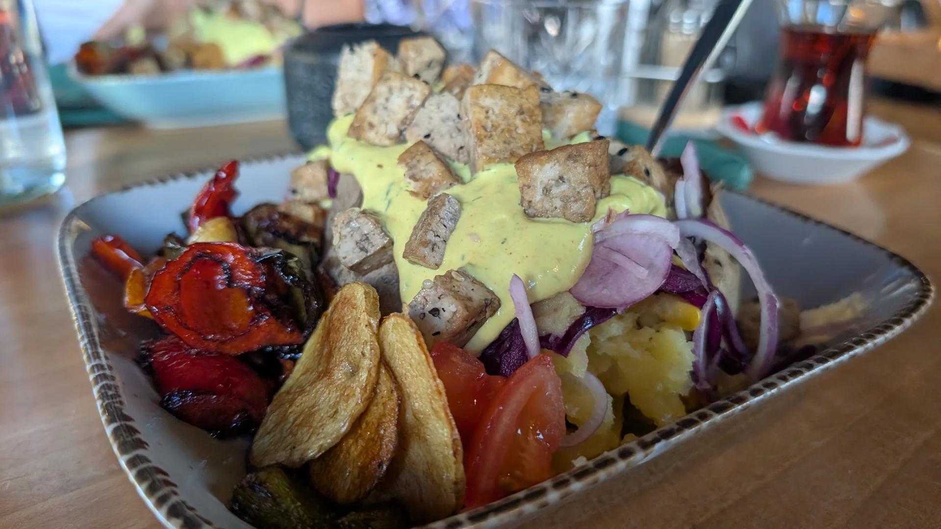 Vegan Kumpir im Gude Vibes Uelzen, Riesenkartoffel mit Tofu, Grillgemüse und roten Zwiebeln