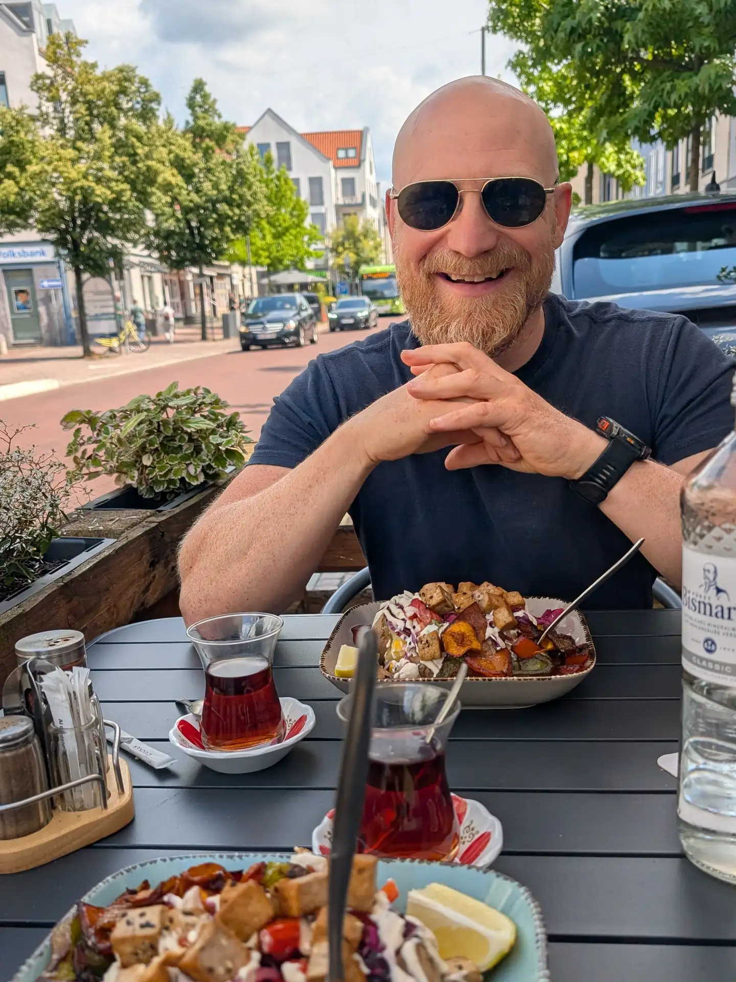 Martin draußen vor dem Gude Vibes Uelzen mit zwei Kumpir und türkischem Tee