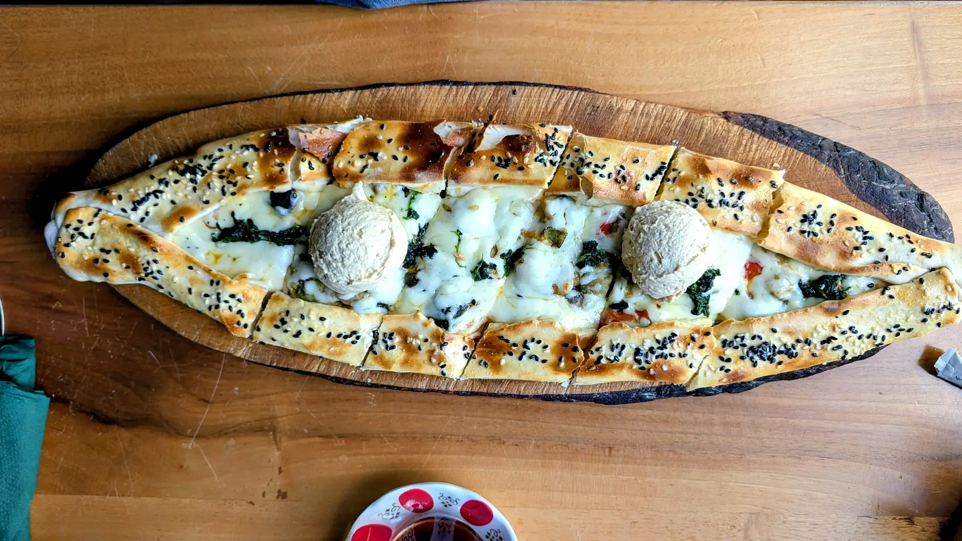Gude Pide mit Spinat, Käse und zwei Kleksen Hummus im Gude Vibes Uelzen, von oben fotografiert