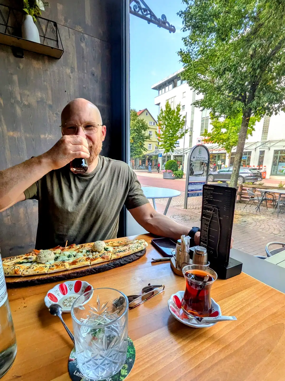 Martin am Fensterplatz im Gude Vibes Uelzen mit Gude Pide und türkischem Tee, Blick auf die Fußgängerzone