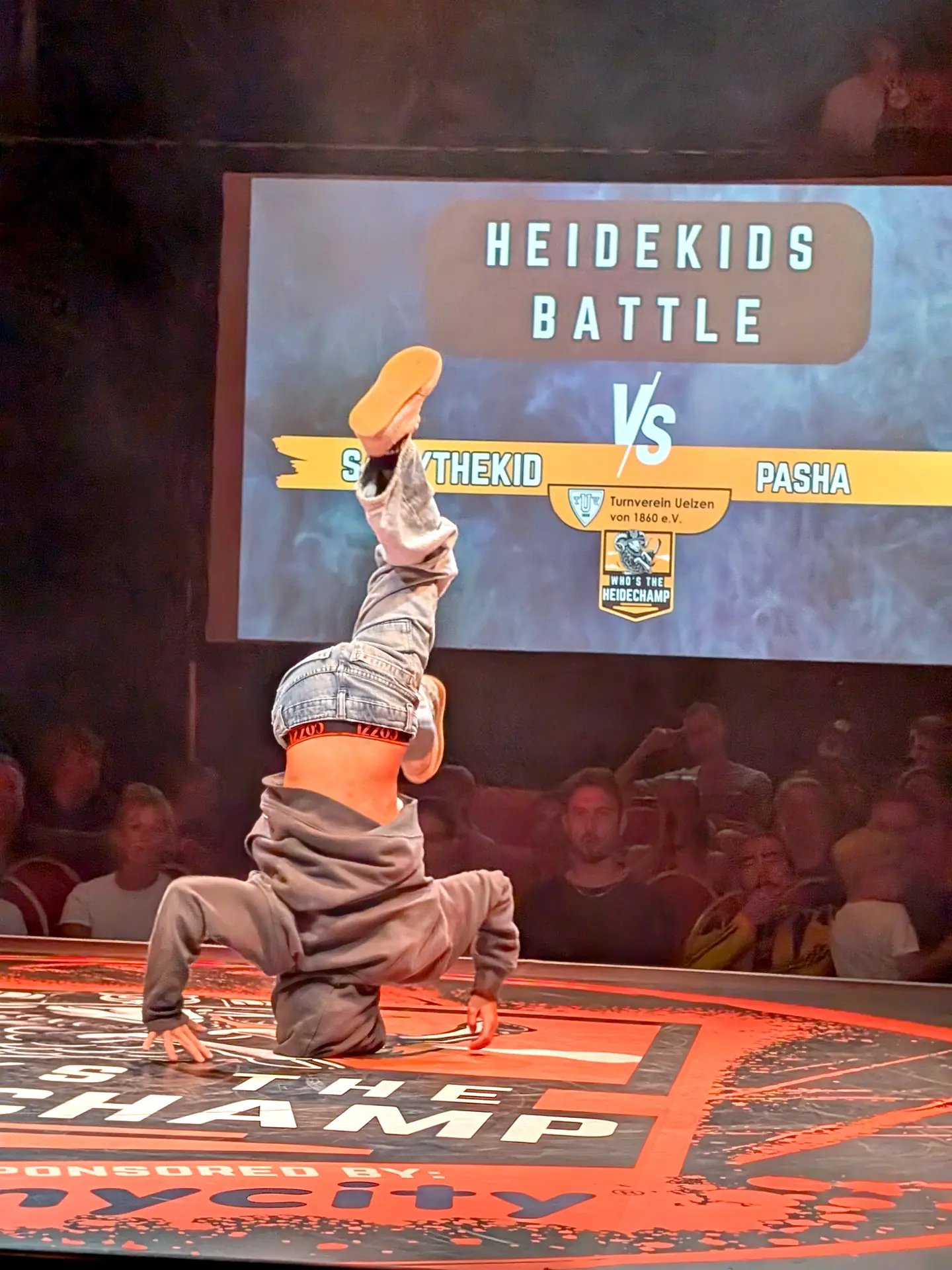 Heidekids Battle beim Who's the Heidechampion Uelzen, junger Tänzer im Headspin vor der Leinwand