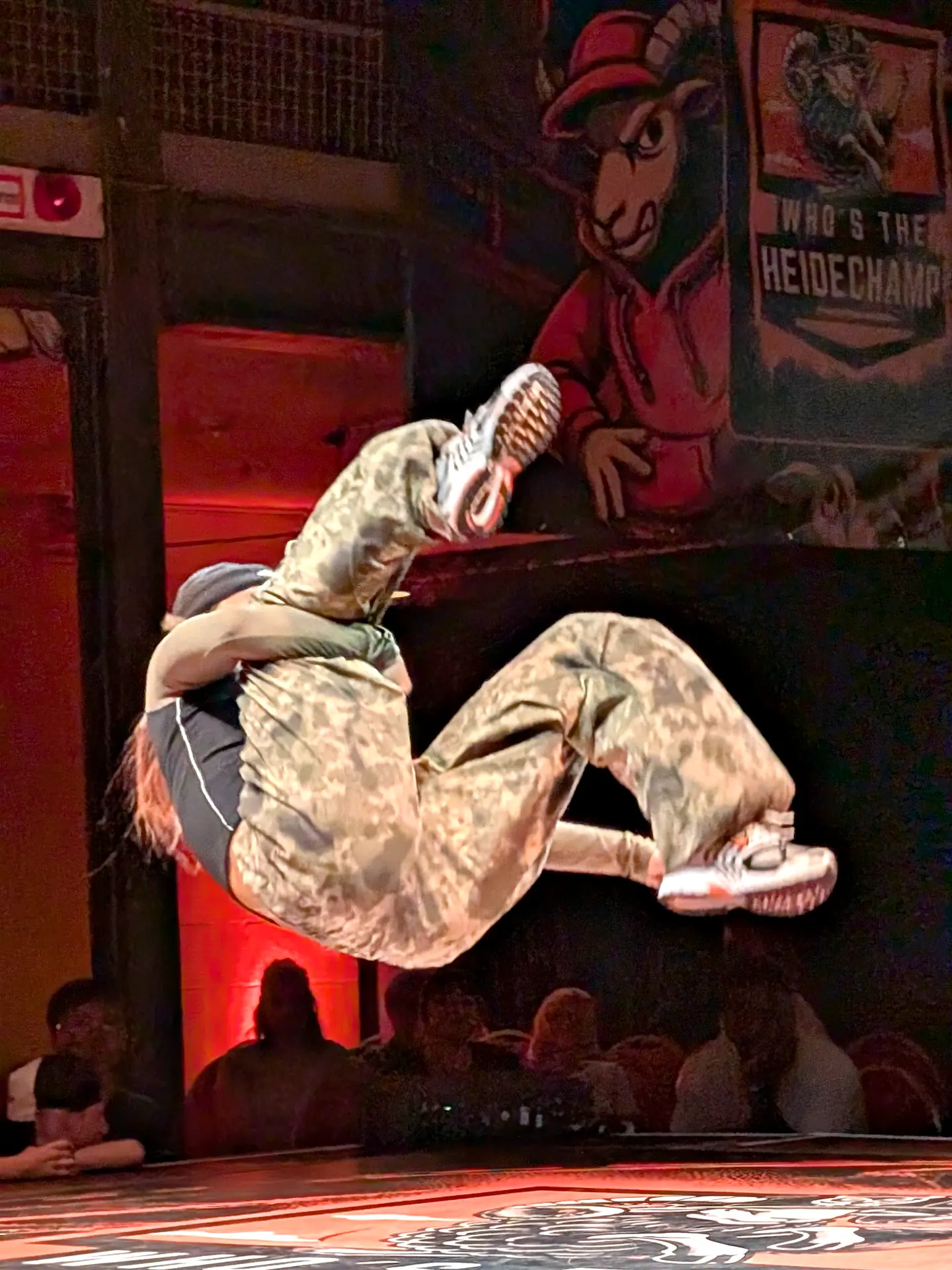 Breaking-Move in der Luft beim Heidechampion Uelzen, im Hintergrund das Festival-Banner