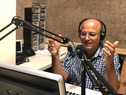 Locutor de Vida 97.1 FM frente al micrófono durante un programa