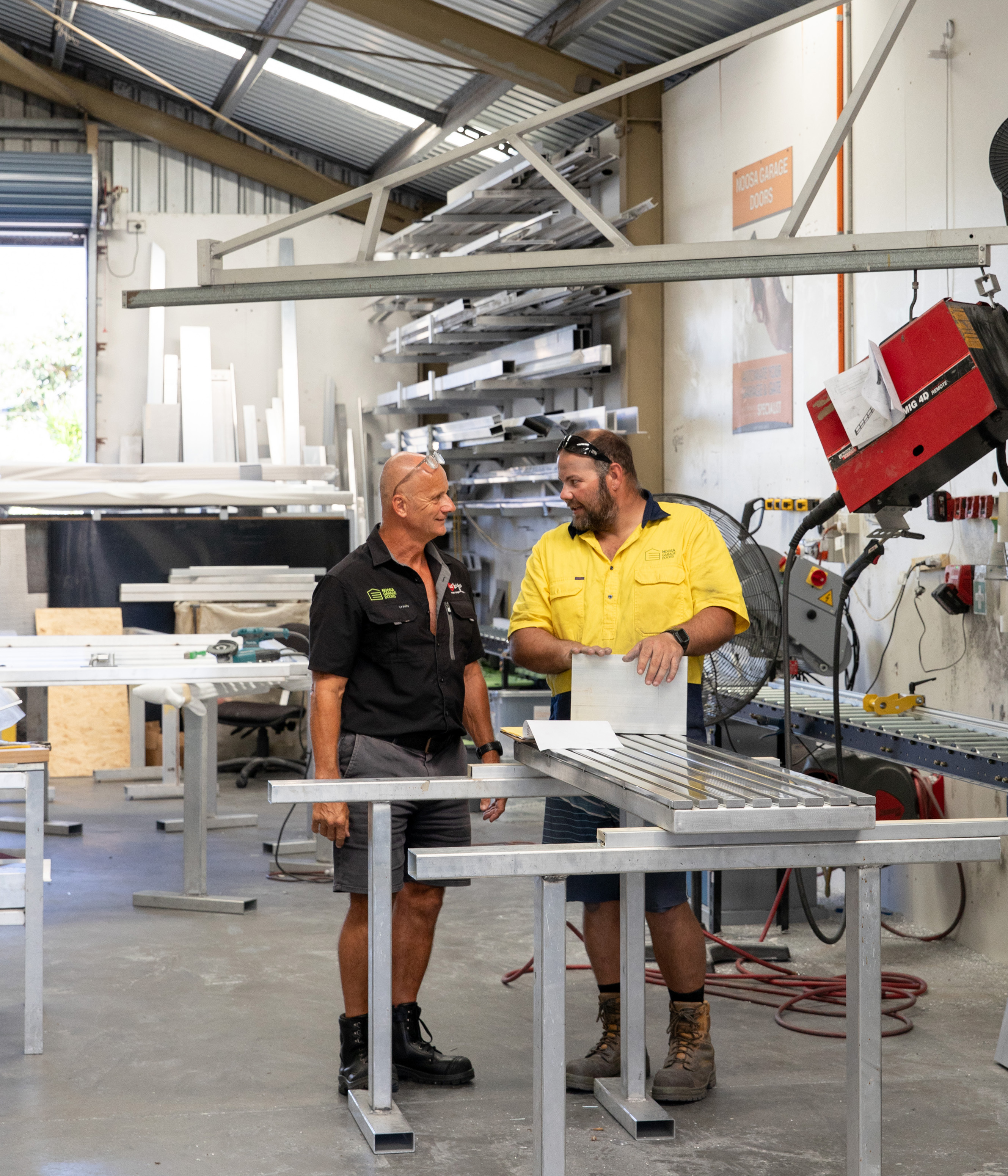 Two workers in BetterWood factory talking about timberlook aluminium