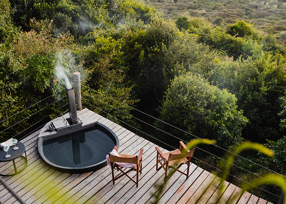 Expansive deck with hot tub and loungers overlooking the savannah.