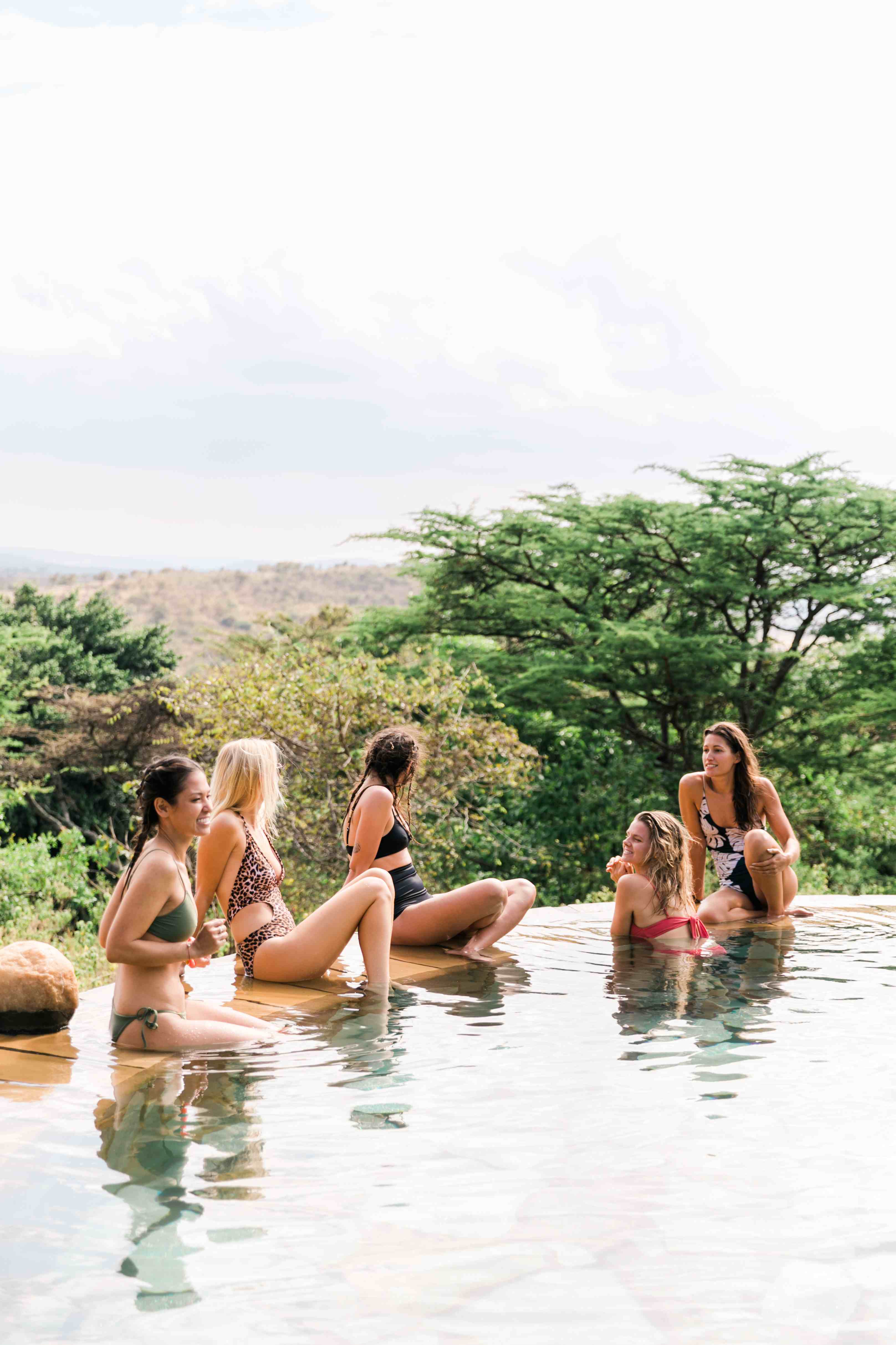 Guests relaxing beside the villa’s infinity pool with panoramic views.