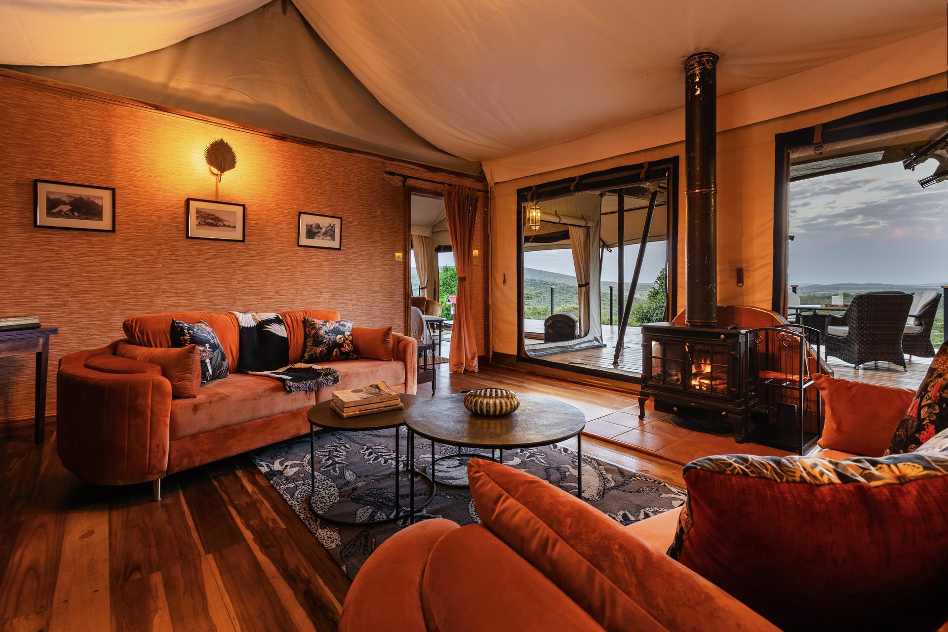 Tiva Family Tent Lounge Tiva Family Tent at Cottar’s 1920s Camp with twin bedrooms, lounge area, and sunset-inspired colour scheme using sustainable materials.