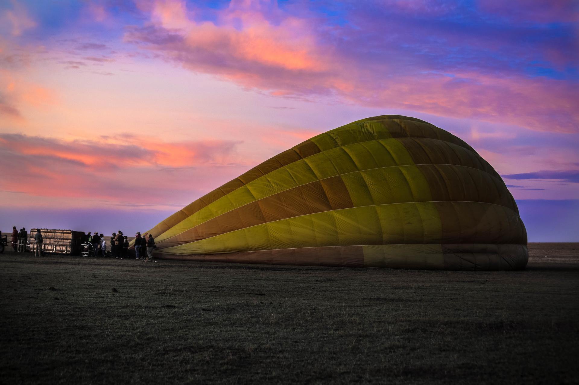 Hot air balloon floating above the Mara at sunrise.