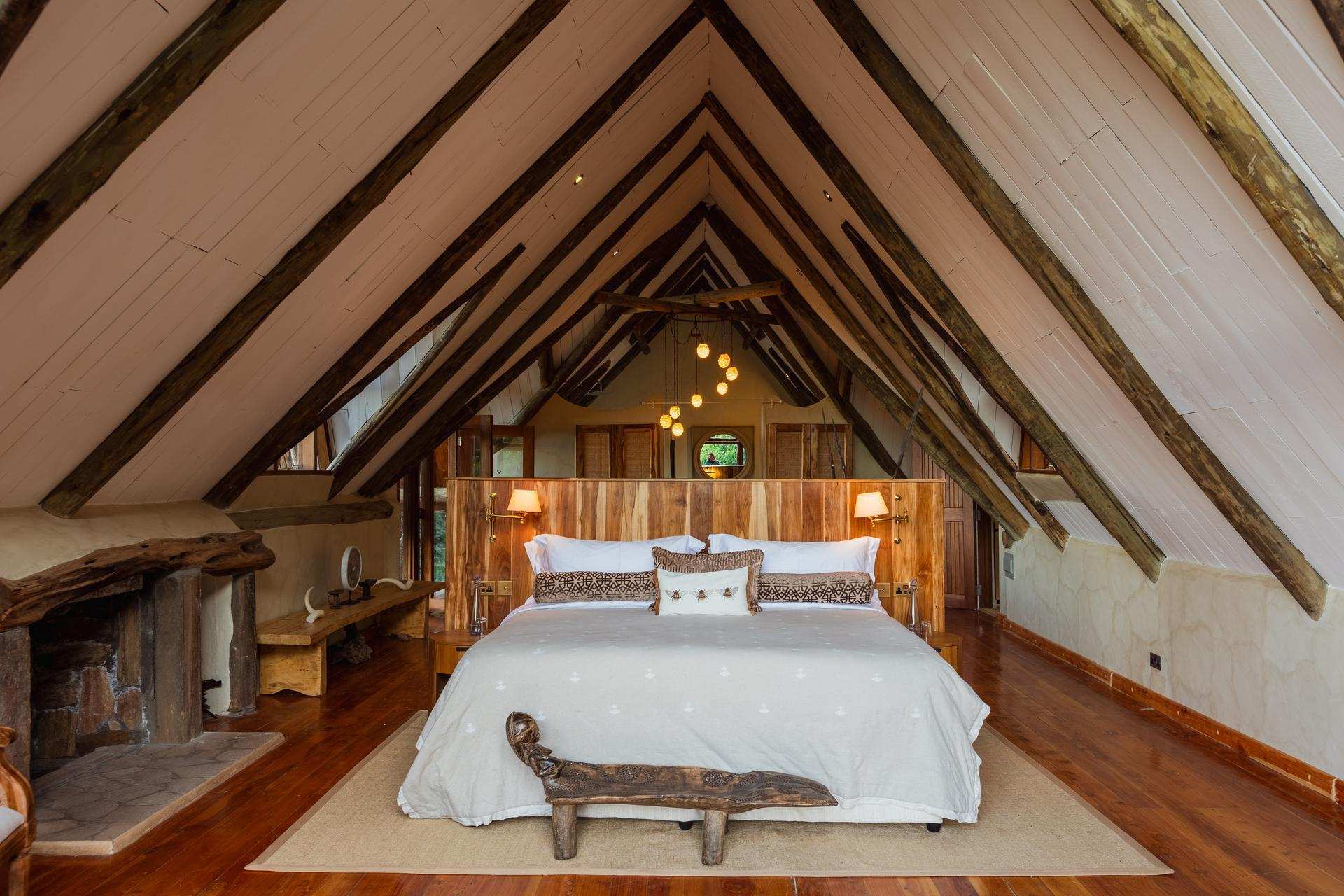 Wide view of the Master Bedroom showing the super-king bed beneath an A-frame timber ceiling.