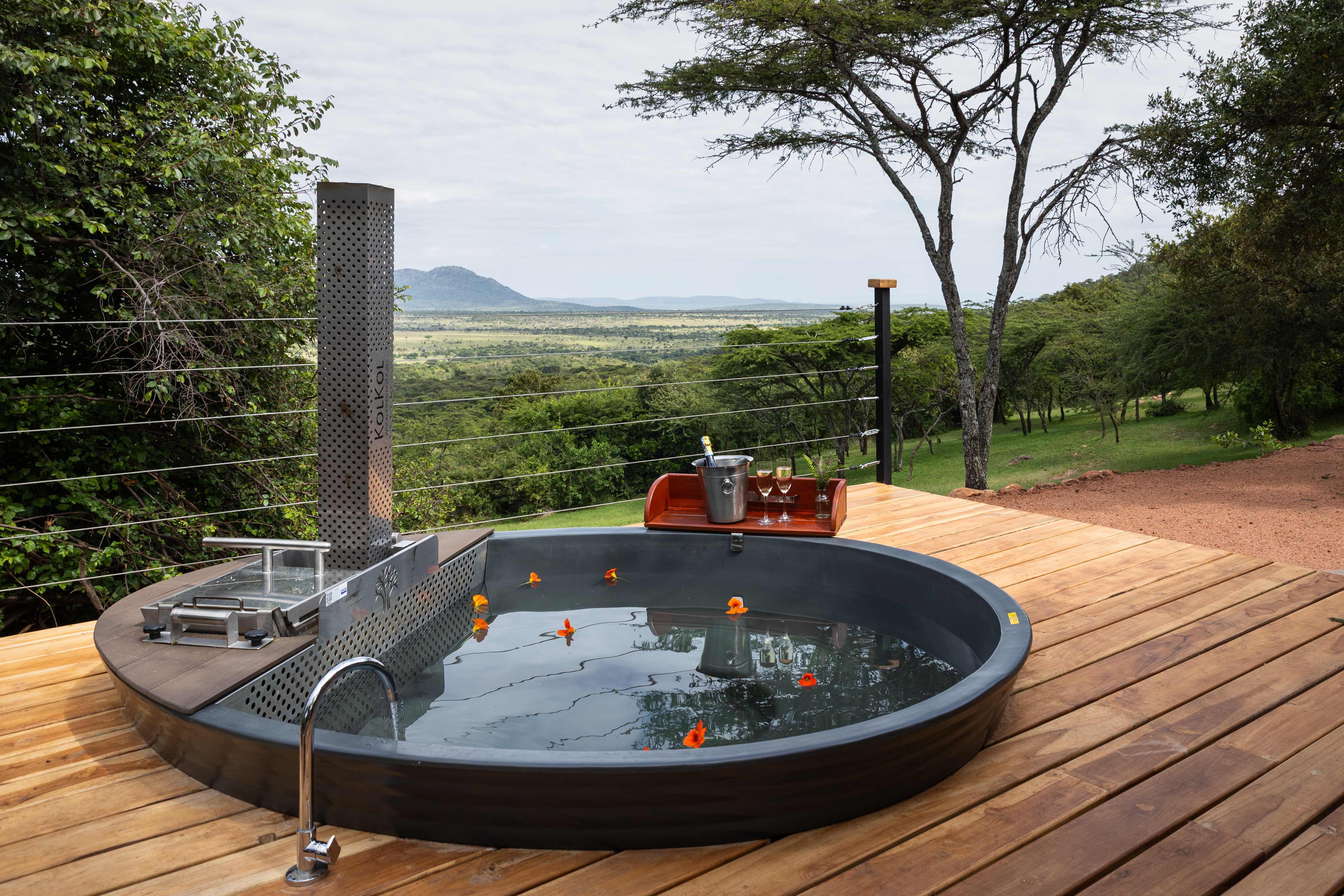 Outdoor wood-fired hot tub on a private deck overlooking the Maasai Mara plains.