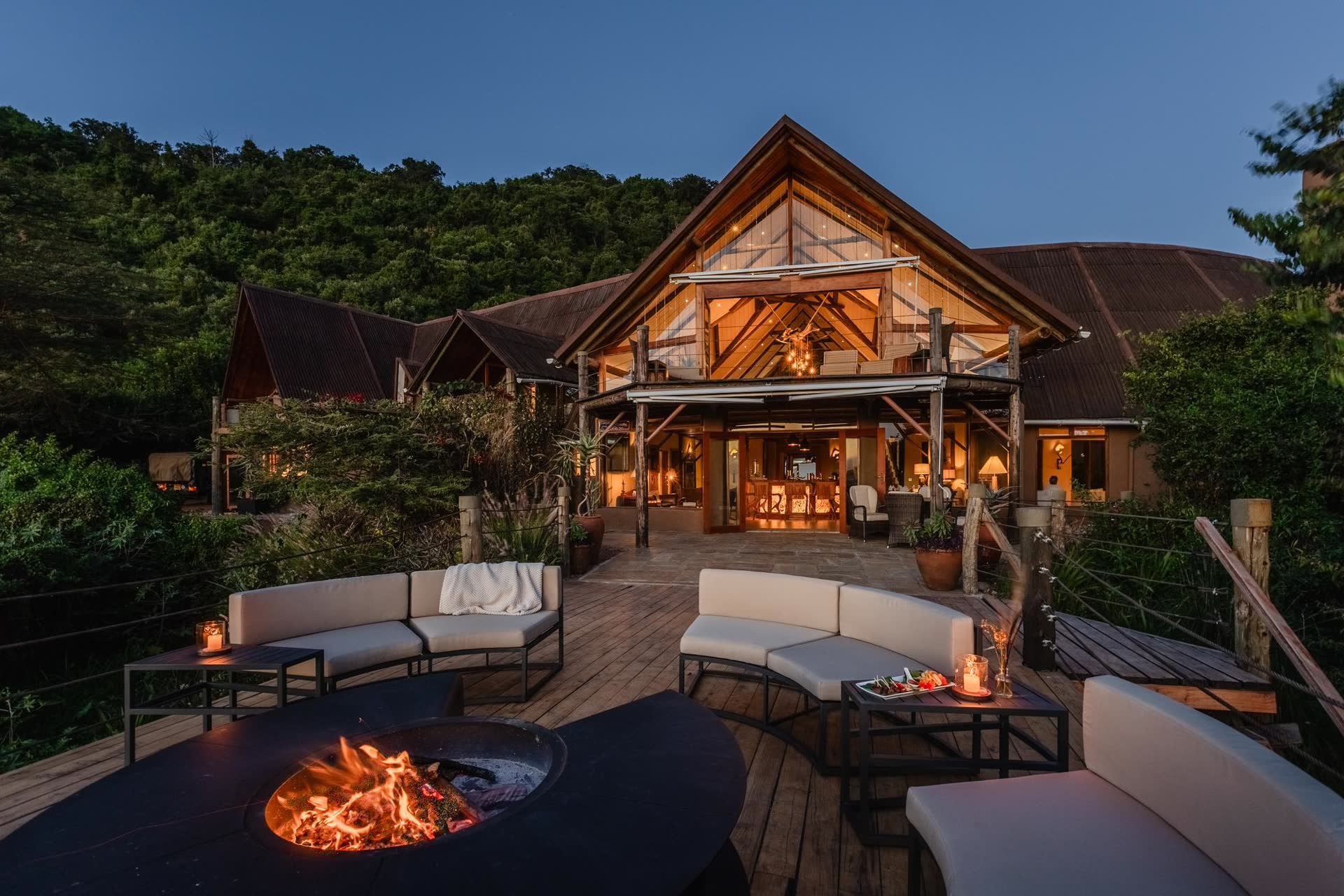 Luxury safari lodge deck with firepit and seating area at dusk in the Maasai Mara.