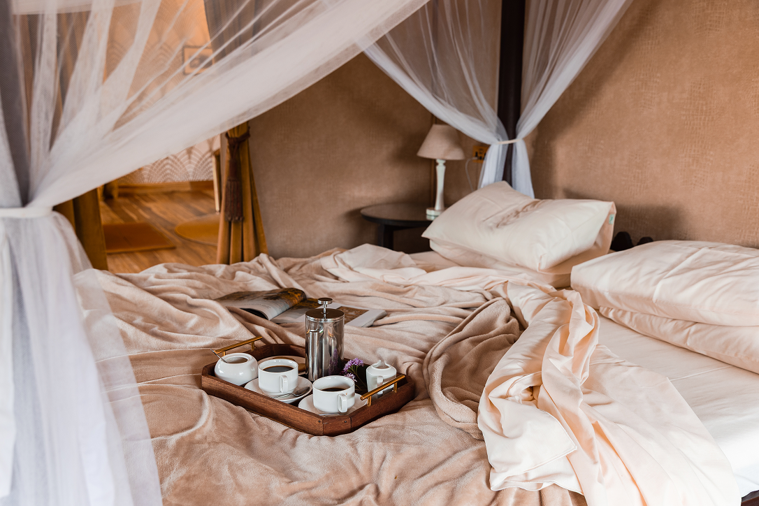 Breakfast served in bed inside a luxury safari tent at Cottar’s Bush Villa.