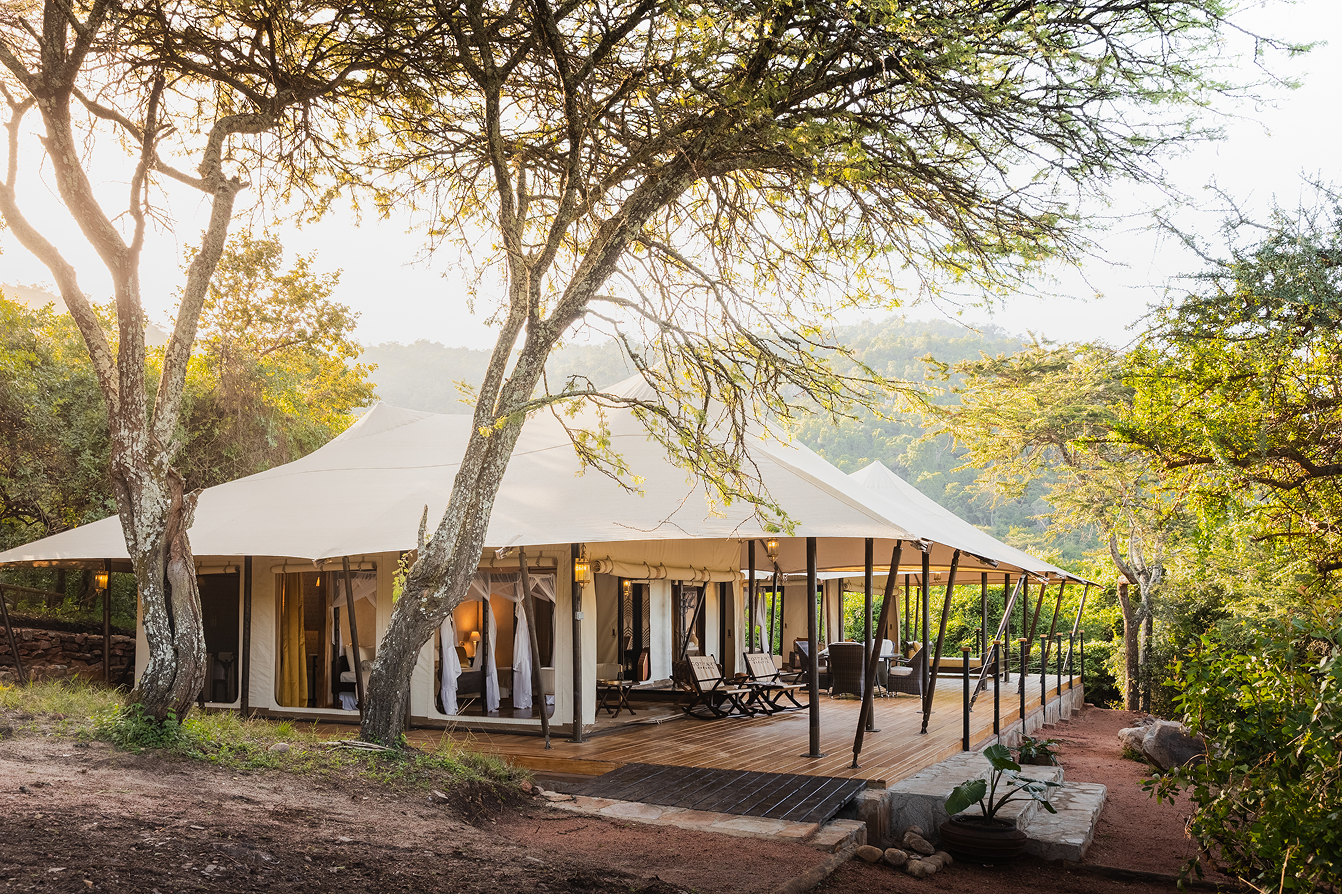 Luxury family safari tent at Cottar’s Bush Villa surrounded by indigenous trees in Kenya.