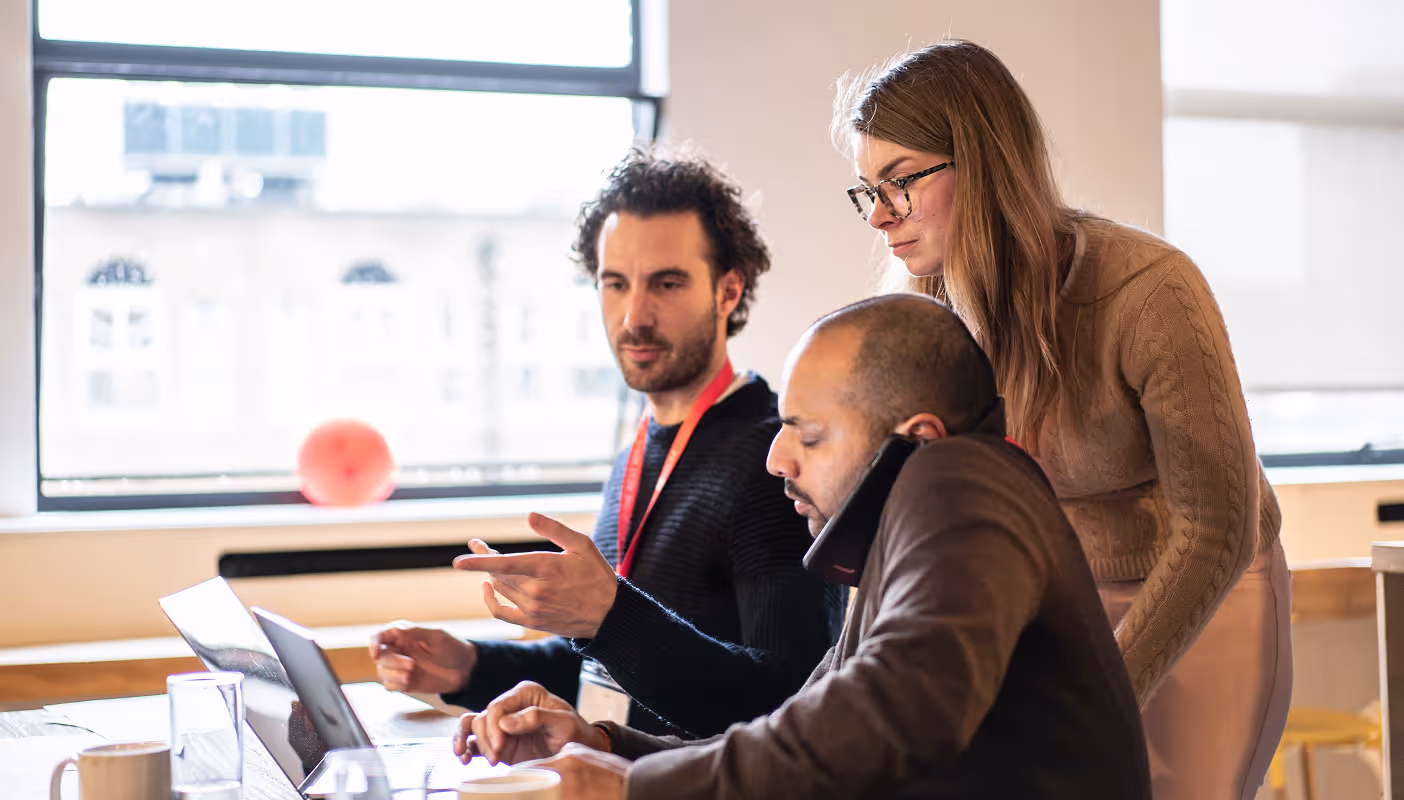 세 명의 앤틀러 창립자들이 영업 미팅 테이블에 앉아 있다