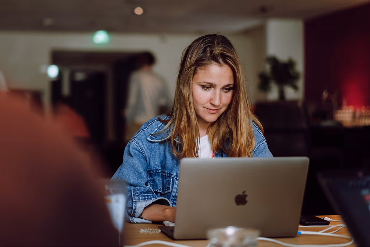 테이블에 앉아 노트북을 사용하는 여성