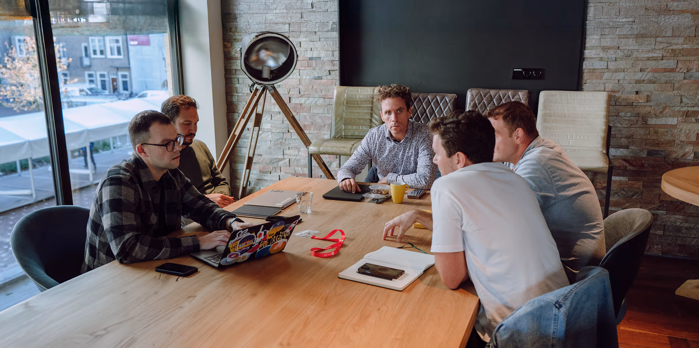 현대적인 사무실 환경에서 회의 테이블을 중심으로 협업하는 창업자와 팀원들.