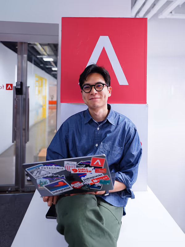 Antler founder sitting down with his laptop smiling