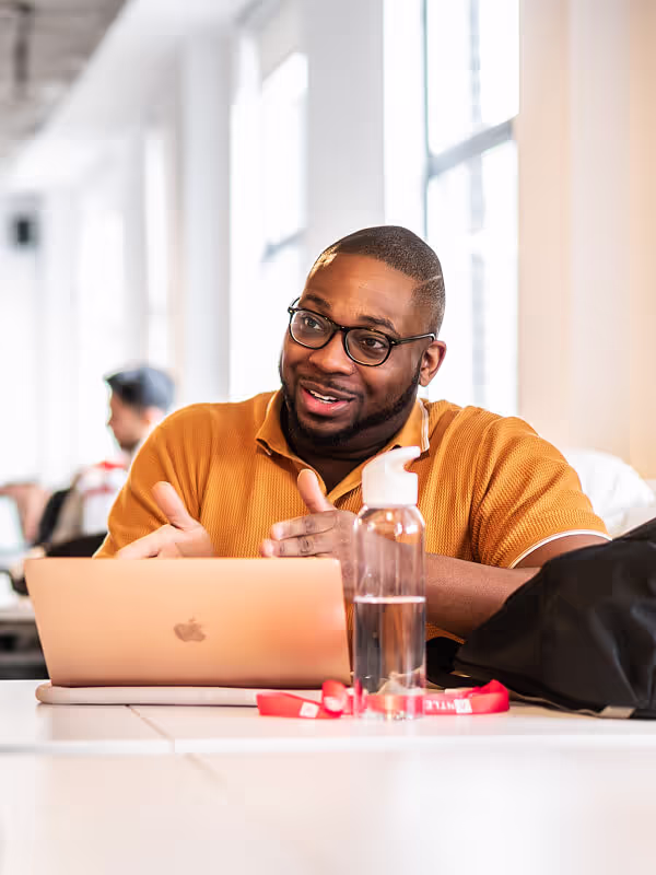 Founder gesturing towards laptop screen
