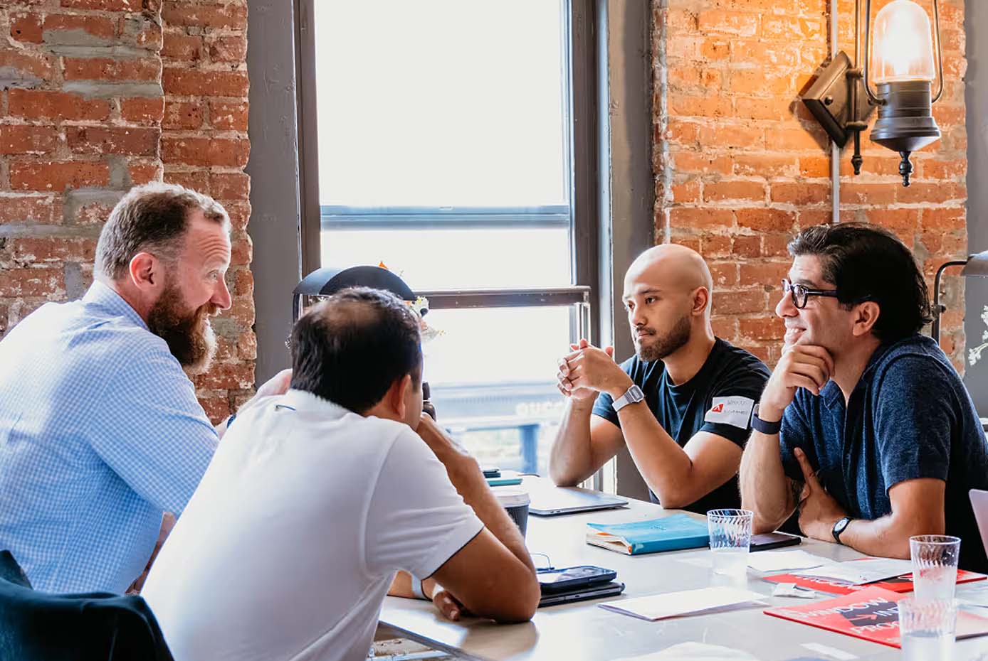 A group of men sitting around a table in a brick building.