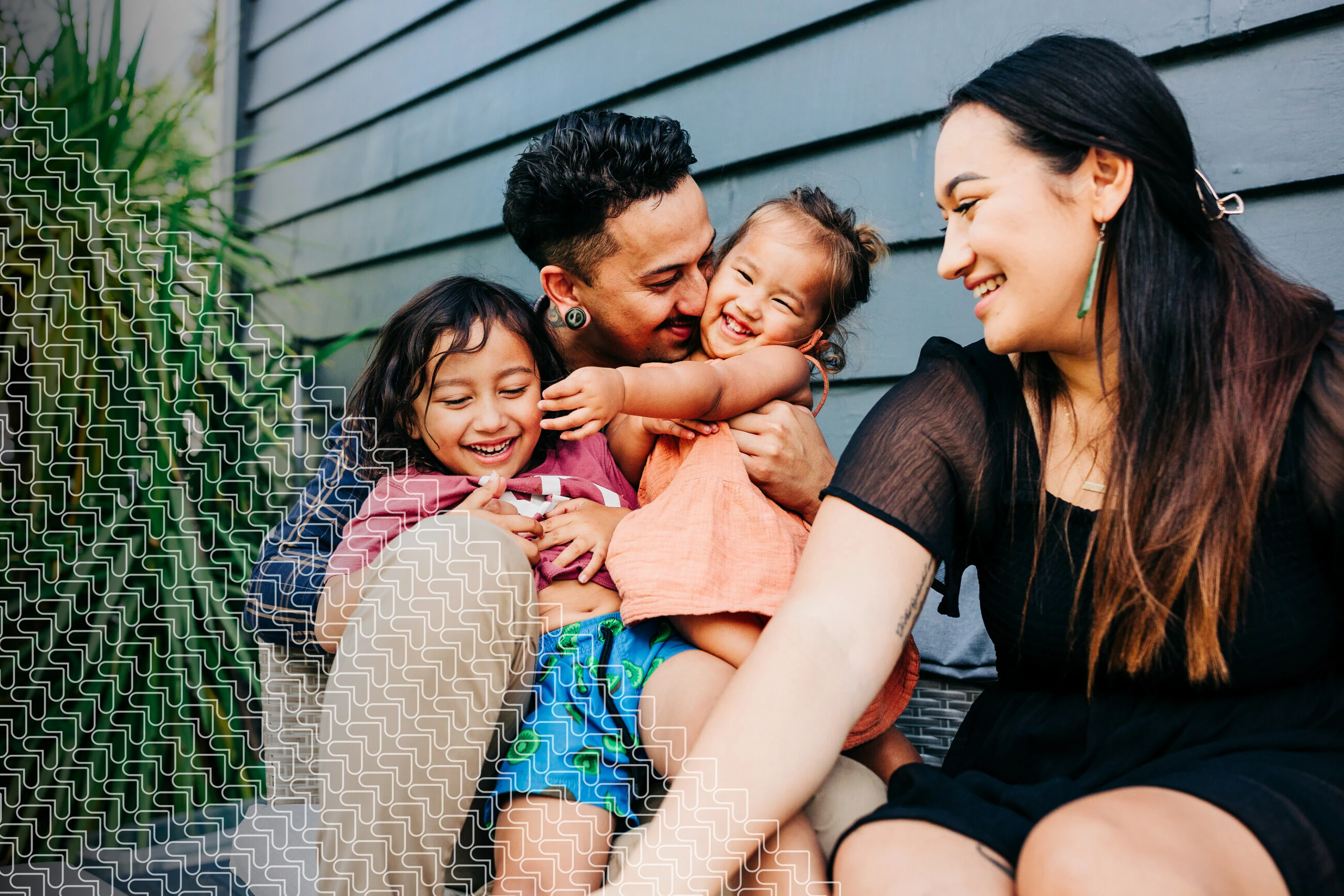 family sitting and smiling, casually outside home