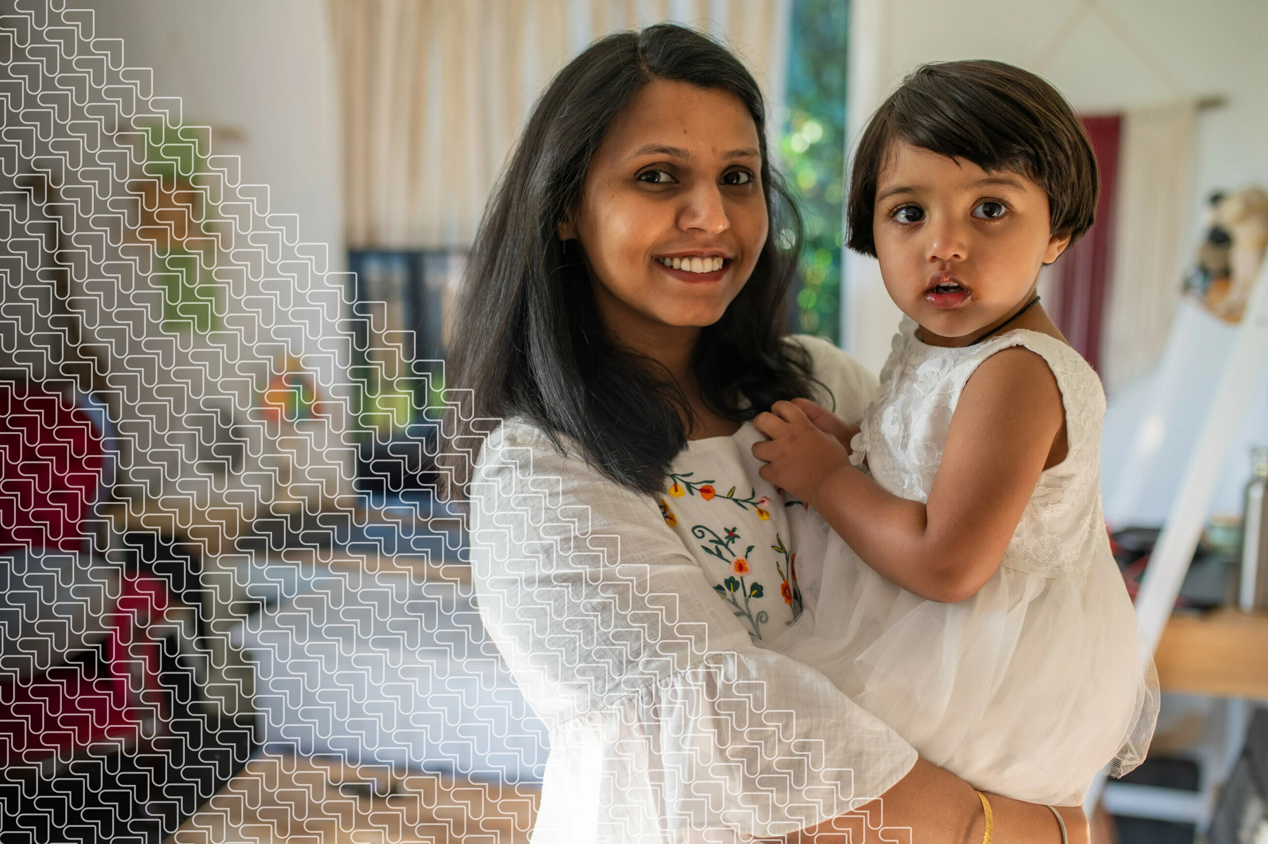 mother holding toddler in lounge at home - smiling