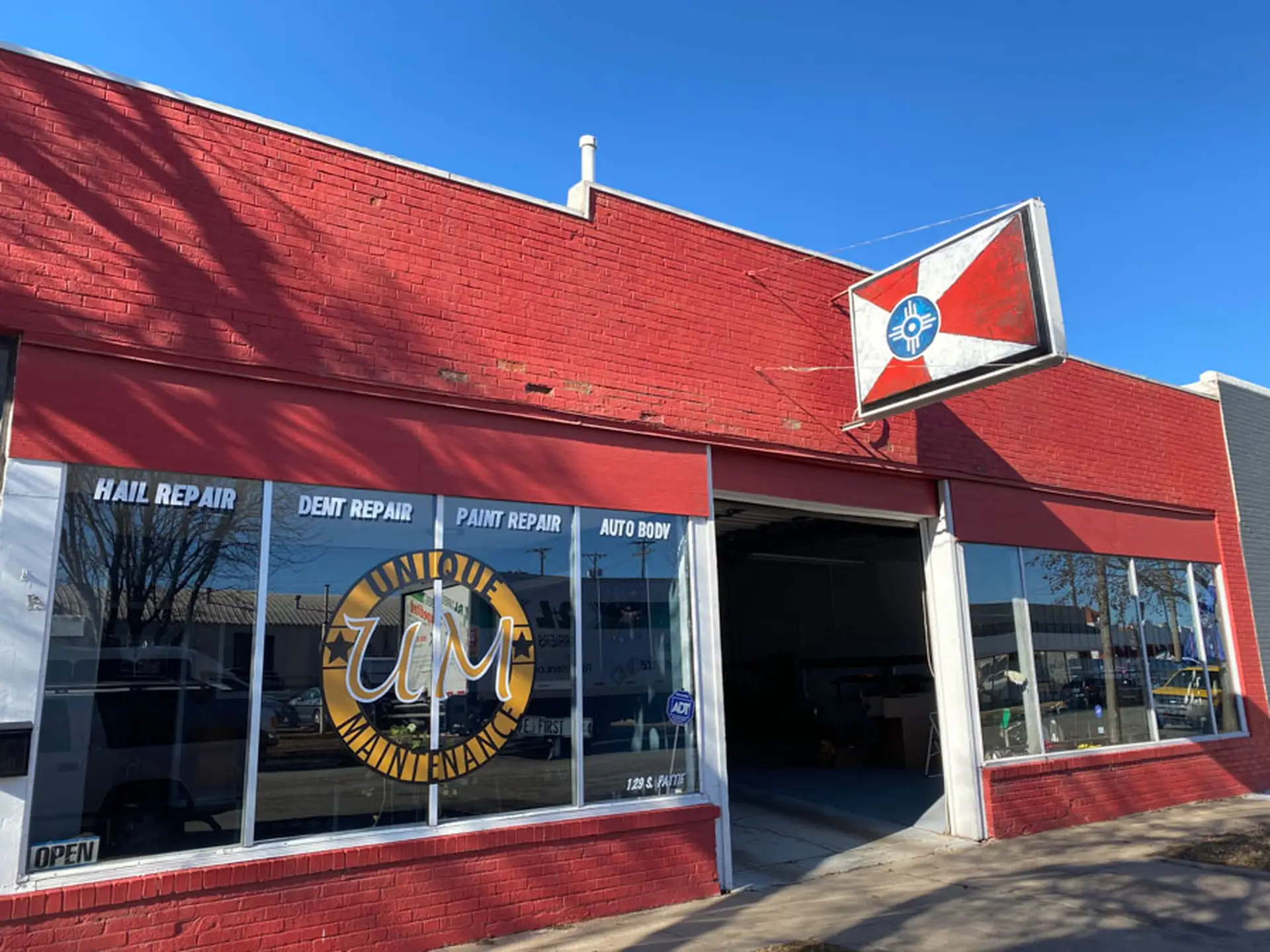 Professional paintless dent repair technician examining vehicle in Wichita auto body shop