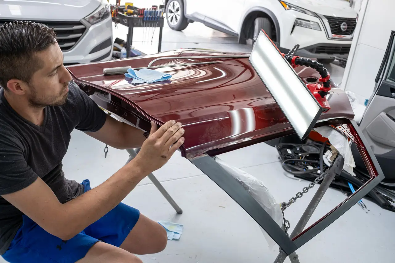 Expert PDR technician using specialized tools for paintless dent repair on vehicle body panel