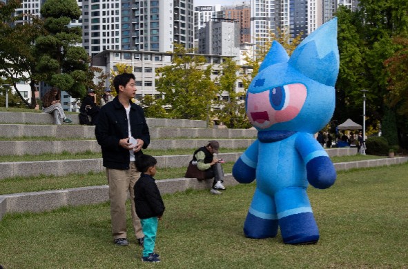 A man and a child in a doll mask