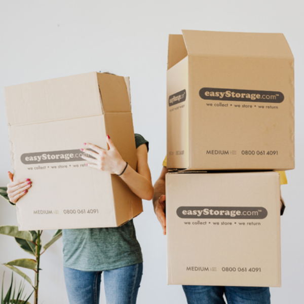 Man and woman holding easyStorage moving boxes over their faces