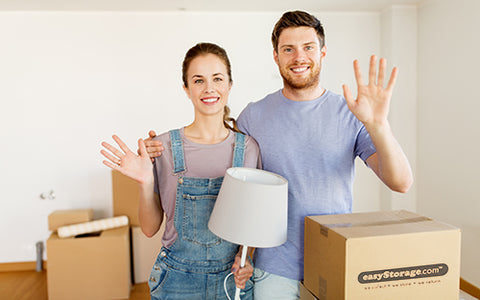 A happy couple holding lamps next to easyStorage Boxes