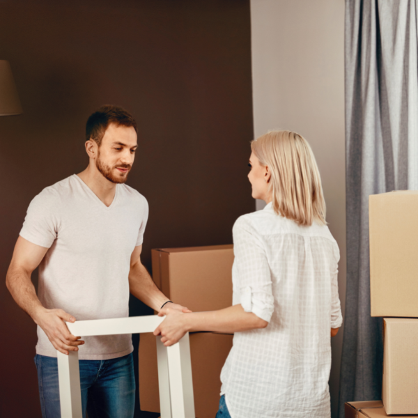A couple moving a table into their new house