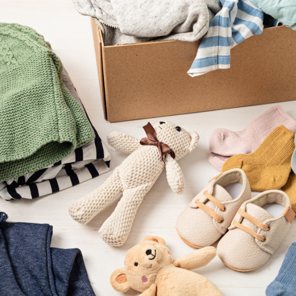 Cardboard moving box with baby clothes and toys