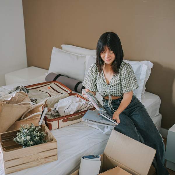 Young woman packing and decluttering her bedroom