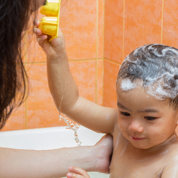 baby boy playing in the bath with mother