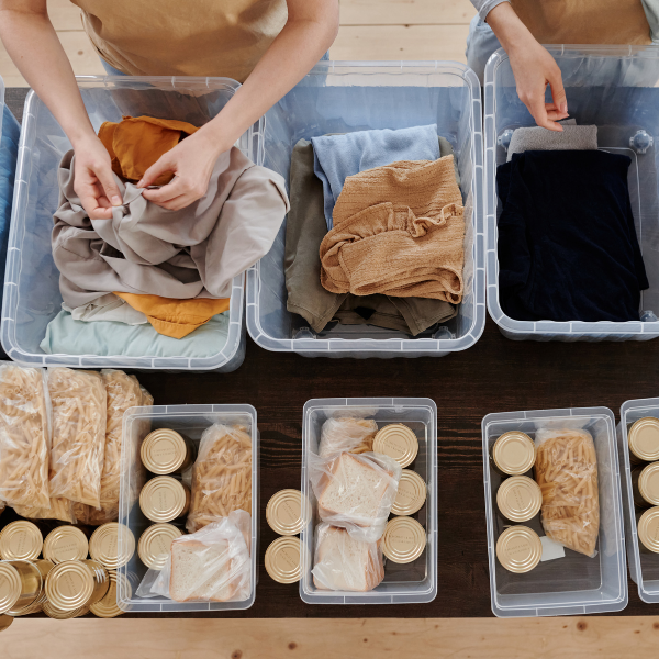 Clothes and food supplies being sorted into plastic boxes