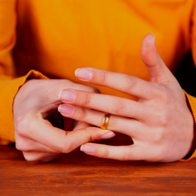 Person wearing orange playing with their wedding ring 
