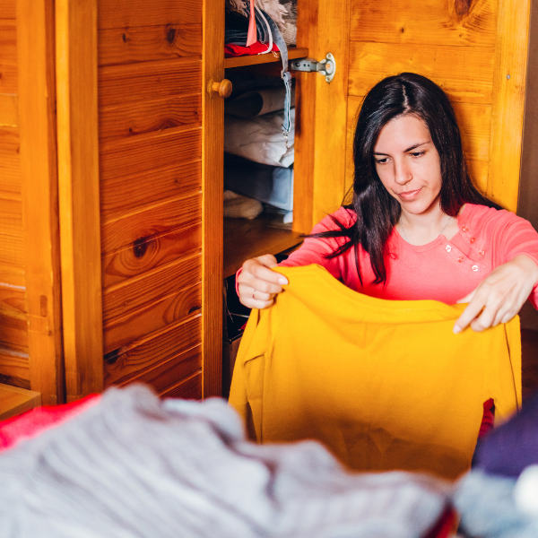 Woman sorting through her summer and winter wardrobe
