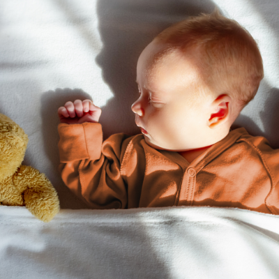 A sweet baby fast asleep with their favourite teddy